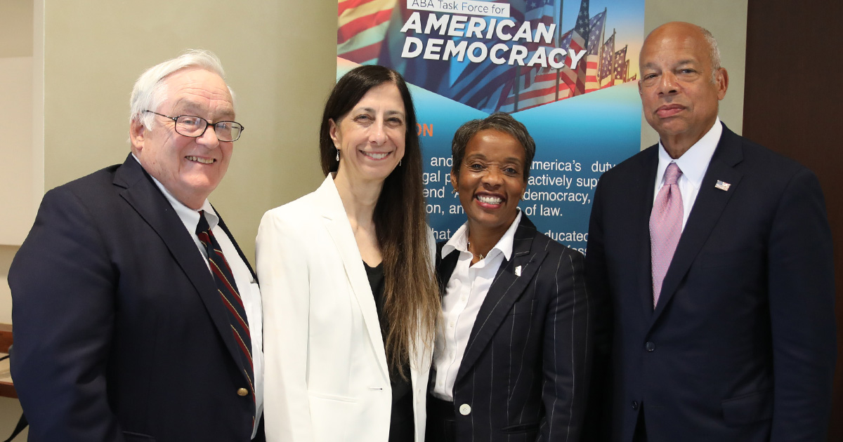 four people smile at the camera