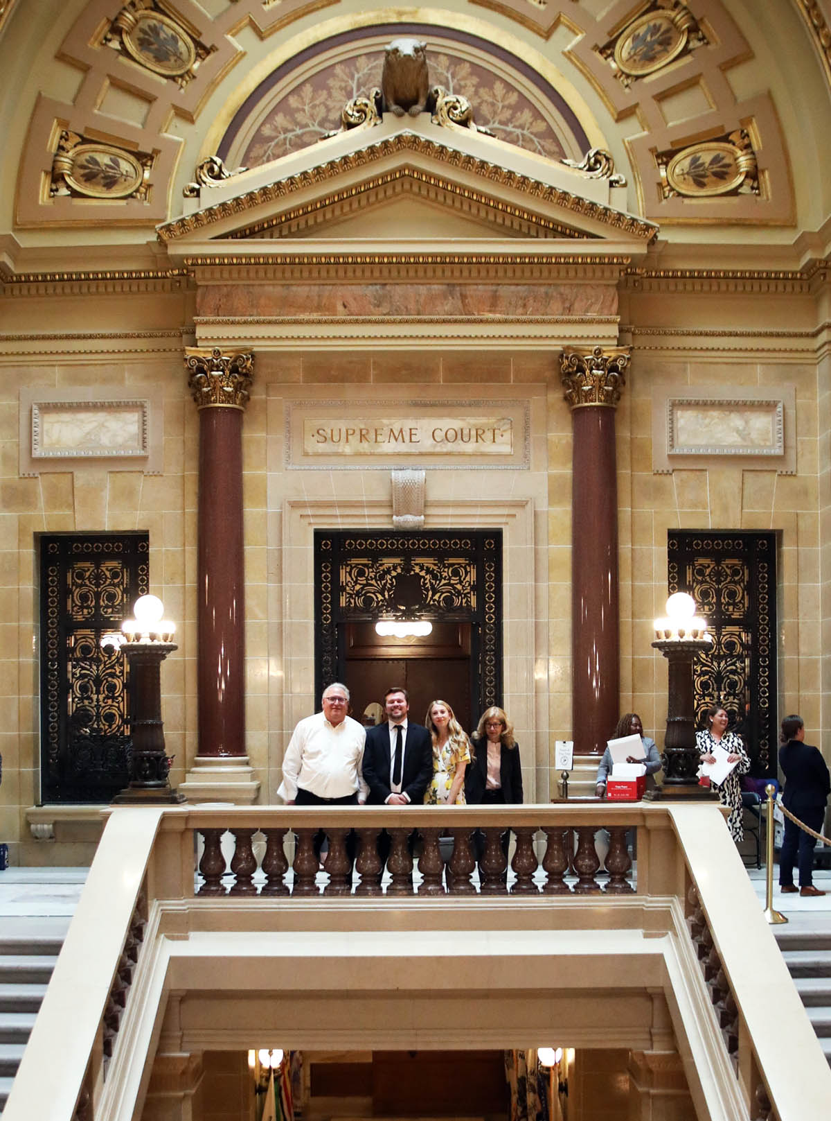 two people stand at a distance with seated people looking on