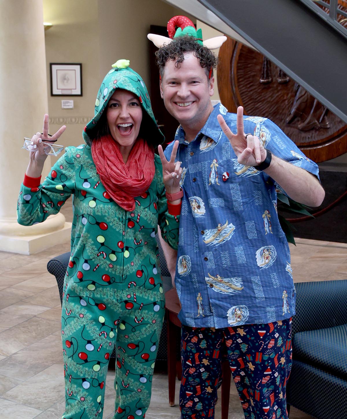 two people in holiday attired smile at the camera