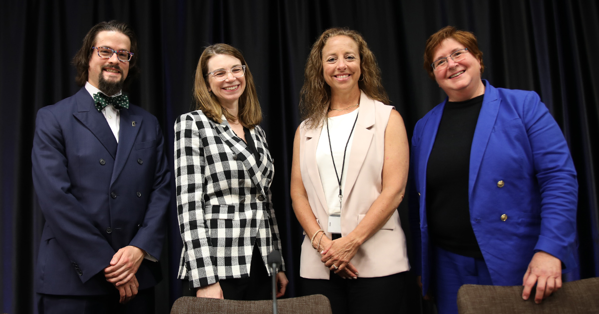 Four people smiling at the camera