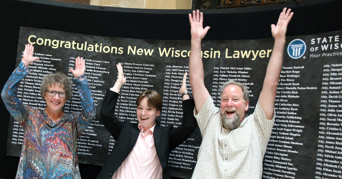 three people throwing their arms up in the air