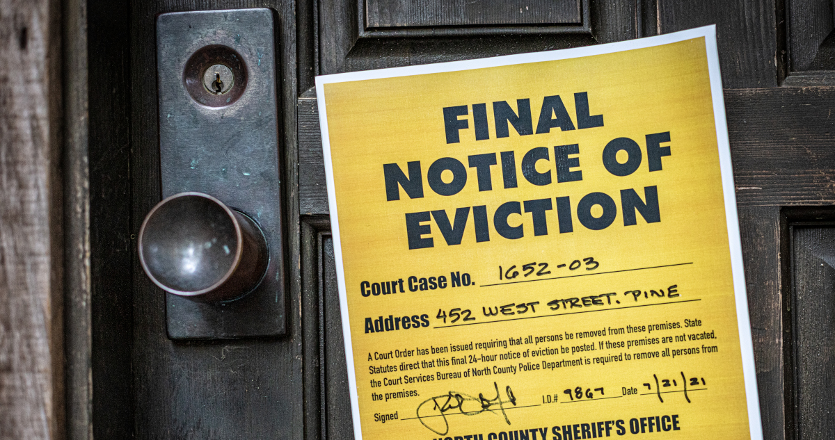 A Yellow Notice, Taped To A Black Wooden Door, That Reads Final Notice Of Eviction, Sheriff's Office