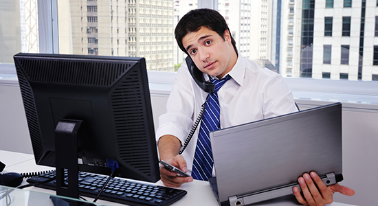 businessman multitasking with computers
