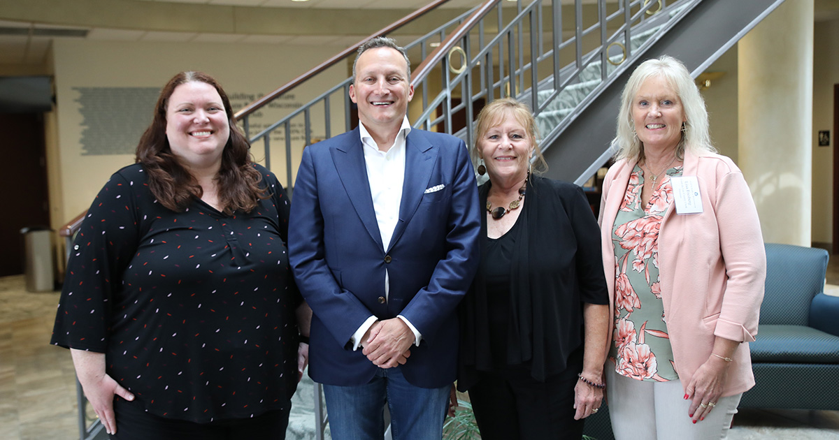 four people smile at the camera
