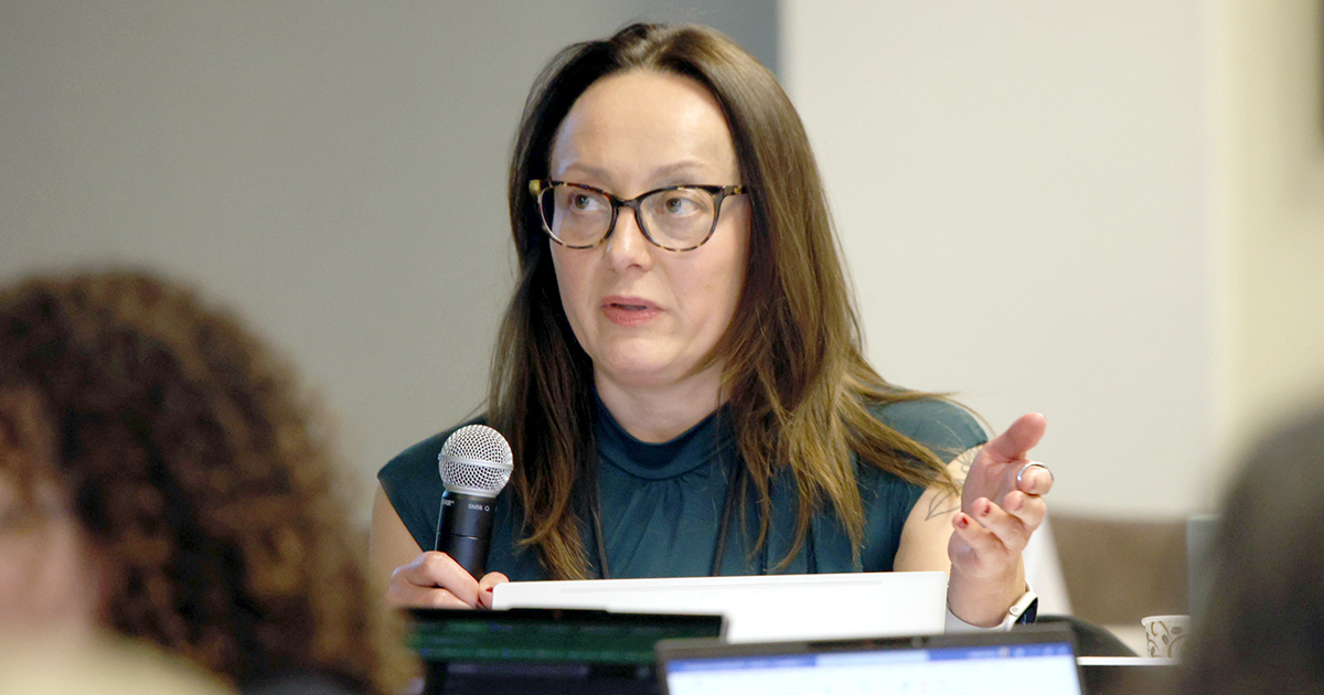 a seated woman speaks into a microphone
