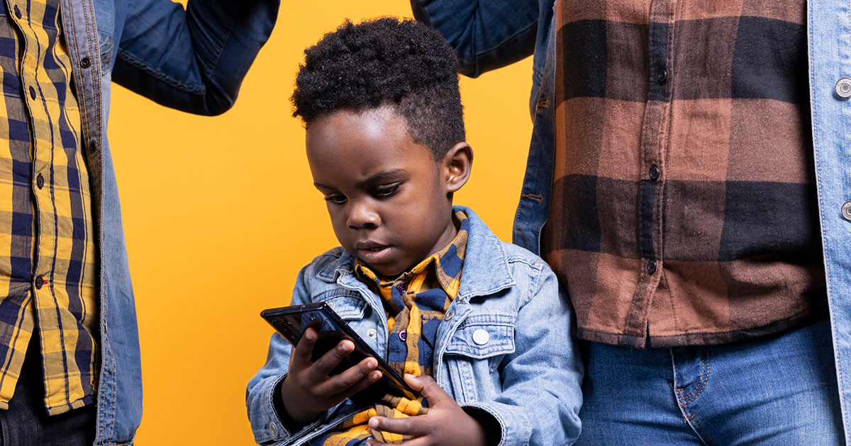 child with cellphone between two parents