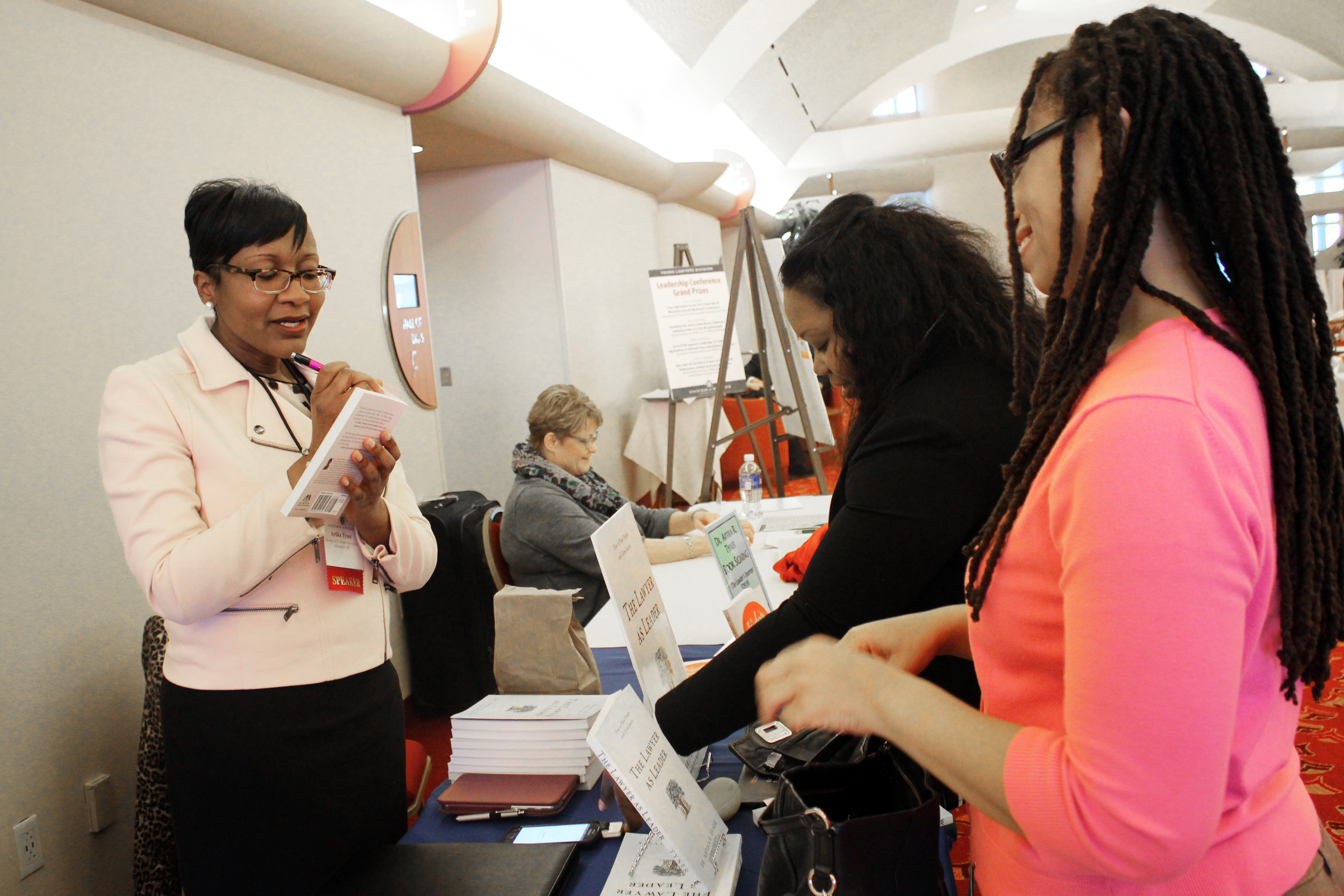 Dr. Artika Tyner signs a book at 2016 Leadership Development Summit